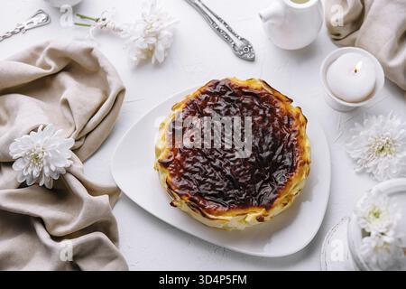 Essen, köstliches Pastell de nata mit karamellisierter Platte, serviert auf einem weißen Teller, umgeben von elegantem Tischdekor Stockfoto