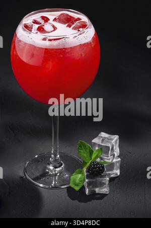 Essen, kalter Cocktail mit Erdbeeren und Eis auf schwarzem Hintergrund Stockfoto