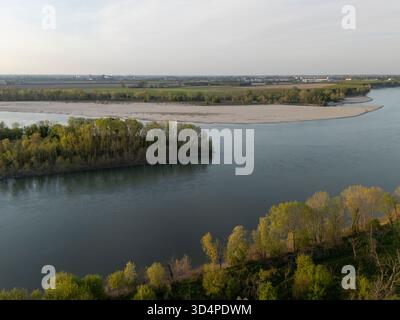 Malerische italienische Landschaft Blick auf den majestätischen Po Fluss, der durch die fruchtbaren Ebenen von Cremona fließt, bei einem atemberaubenden Sonnenuntergang, der goldene Töne auf der tr ausstrahlt Stockfoto
