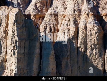 Nahaufnahme der hoch aufragenden, stark erodierten Erdsäulen (wahrscheinlich aus Badlands) in der Nähe des Amadorio Reservoir, mit tiefen Schatten und starken Kontrasten Stockfoto