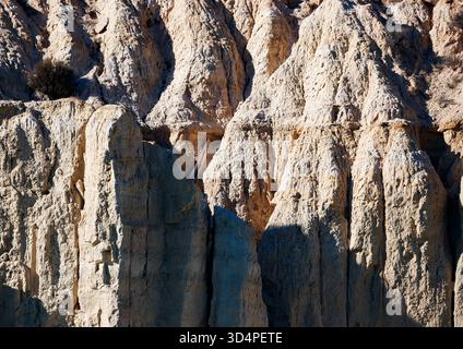 Ein detailliertes Bild von sonnenverwöhnten, hellen, erodierten Felsformationen am Amadorio Reservoir, mit scharfen Gipfeln, zerklüfteten Oberflächen und dem kontrastreichen Te Stockfoto