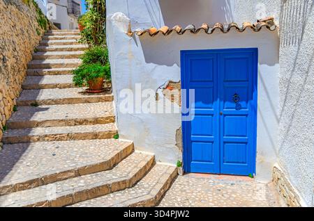 Altea Altstadt enge Straße, Treppenstufen, typische weiße Häuser traditionelle Gebäude mit blauer Tür, Blumen Pflanzen in Töpfen an sonnigen Sommertagen, Stockfoto