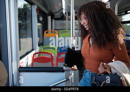Junge Frau, die mit einem digitalen Tablet im Bus pendelt Stockfoto