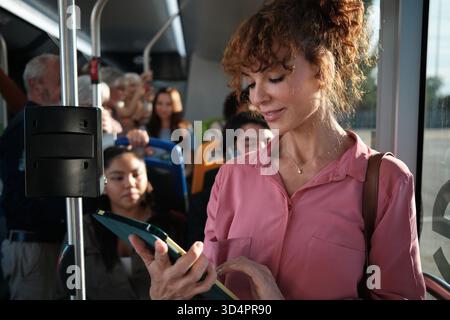 Pendlerin mit Tablet im Bus öffentlicher Verkehrsmittel Stockfoto