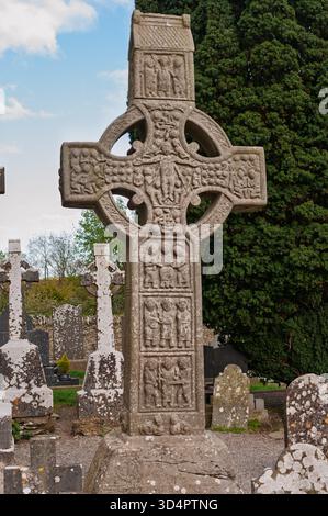 Ein großes Steinkreuz mit einem Kreuz darüber. Das Kreuz ist von einem Friedhof umgeben Stockfoto