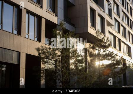 Ein moderner Wohnkomplex leuchtet im warmen Licht des Sonnenuntergangs und bietet elegante, moderne Architektur und urbanes Design. Stockfoto