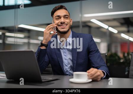 Ein erfolgreicher Geschäftsmann hat während seiner Arbeit an seinem Schreibtisch telefoniert Stockfoto