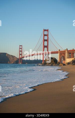 17. OCT 2025 - San Francisco, USA - die Golden Gate Bridge von der westlichen Seite aus gesehen während der Dämmerung vom Marshalls Beach mit Strand und Küste in Th Stockfoto