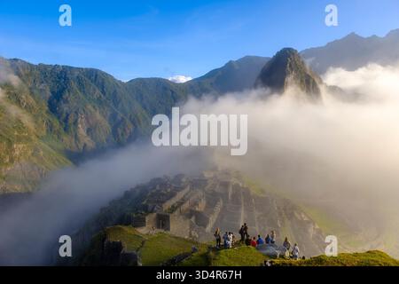 Sonnenaufgang Nebel, Menschen, Gruppe von Touristen besuchen Machu Picchu Ruinen im Heiligen Tal der Inkas, Peru Stockfoto