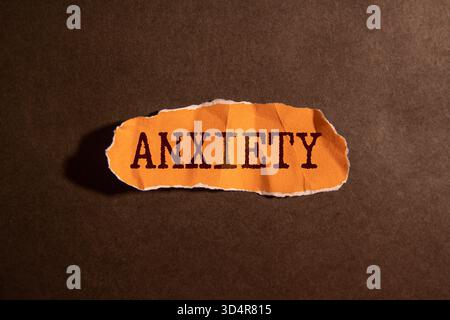 Angst Wort Buchstaben Text handgeschriebenes Kalligraphie Design auf weißem Papier Etikett Anmerkung isoliert auf einer roten Hintergrund Oberfläche mit Kopierraum. Makroaufnahmemodus Stockfoto