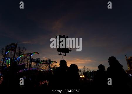 Hochheim, Hessen, Deutschland. November 2025. Ein Mann hält einen Peppa Pig Ballon bei Sonnenuntergang während des Hochheimer Marktes in Hochheim. Die traditionelle Herbstmesse findet seit über 500 Jahren statt. (Kreditbild: © Matias Basualdo/ZUMA Press Wire) NUR REDAKTIONELLE VERWENDUNG! Nicht für kommerzielle ZWECKE! Stockfoto