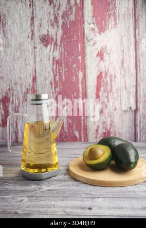Öl und Avocado auf einem Holztisch in einer rustikalen Küche Stockfoto