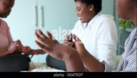 Ich malte die erhobene Hand einer mittelerwachsenen Frau auf dem Bett mit einem Freund in einem weißen Hoodie mit schwarzem nagellack Stockfoto