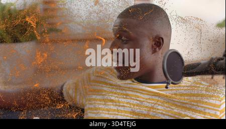 Liegender Mann in gelb gestreiftem T-Stück-Aufnahme auf Sofa zu Hause, mit Mikrofon und Pop-Filter, orange-Staub Stockfoto