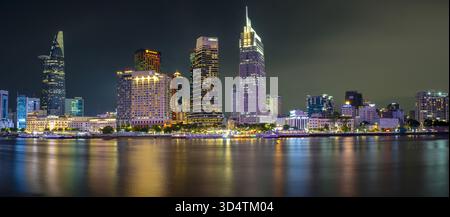 Blick auf den Saigon River, der die leuchtenden Lichter der majestätischen Wolkenkratzer in der Skyline von Ho Chi Minh City bei Nacht reflektiert, Ho Chi Minh City, Ho Chi Stockfoto