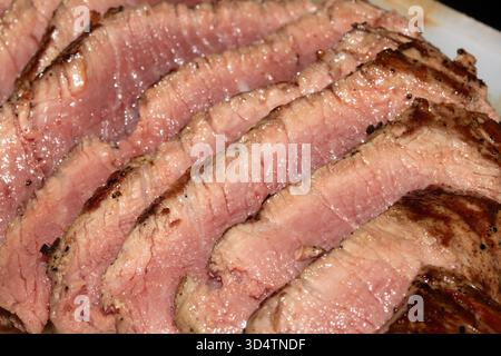 Nahaufnahme von geschnittenem und gewürztem seltenem Steak auf Schneidebrett Stockfoto