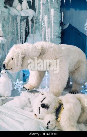 Plüschpolarbärenfamilie mit Schneeflocken und eisigem Höhlenhintergrund in einem Winterthema. Arktische Urlaubsszene. Warschau, Polen, November Stockfoto