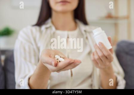 Medikamentenpille in der jungen weiblichen Hand, Frau nimmt Medikamente, tägliche Norm von Vitaminen, wirksame Medikamente Stockfoto