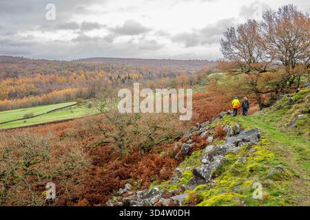 Eine Gruppe von Wanderern, die auf einem felsigen Fußweg spazieren, schneidet in einem Hügel im Derbyshire Peak District nahe Baslow. Stockfoto