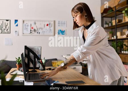 Junge Frau zu Hause, organisiert ihren Schreibtisch und skizziert Ideen in gemütlicher Atmosphäre. Stockfoto