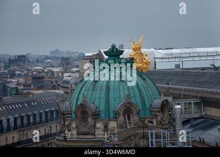 Die grüne Kupferkuppel auf dem Dach der Opéra Garnier in Paris erhebt sich elegant, gekrönt von der goldenen Skulptur der Triumph des Apollo scheint Stockfoto
