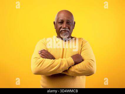 Positiver Senior Afroamerikaner Posiert Selbstbewusst Mit Gekreuzten Armen Vor Orangefarbenem Hintergrund Stockfoto