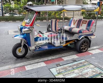 Ein lebhaftes, traditionelles thailändisches Tuk-Tuk, in auffälligen Farben mit VIP-Sitzen gestrichen, steht auf einer Straße in Bangkok. Dieses legendäre Auto mit drei Rädern Stockfoto