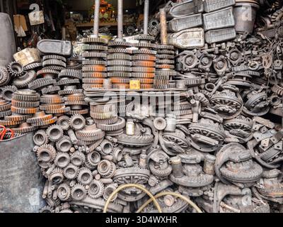 Ein weitläufiger, rostiger Hort alter Metallzahnräder, Zahnräder und verschiedene Industriemaschinen, hoch gestapelt in einer geschäftigen Werkstatt in Bangkok. Ein Beweis dafür Stockfoto