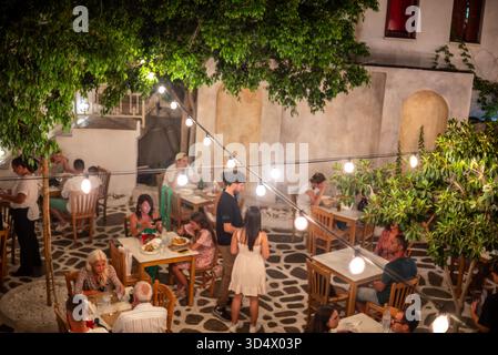 Restaurant im Freien, in dem Gäste unter Lichterketten in einem Innenhof in Naxos, der größten griechischen Kykladen-Inseln in der Ägäis am 20. August, speisen Stockfoto