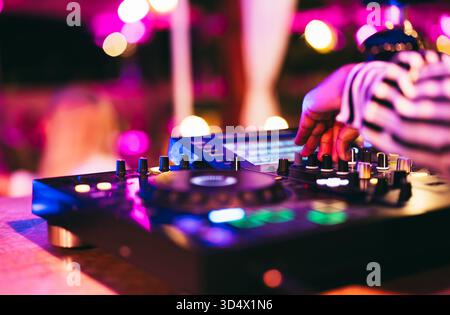 DJ spielt Musik während der Winterfeier in der Cocktailbar - Unterhaltungs- und Clubbingkonzept - Soft Focus auf Disc Jockey Hand Stockfoto