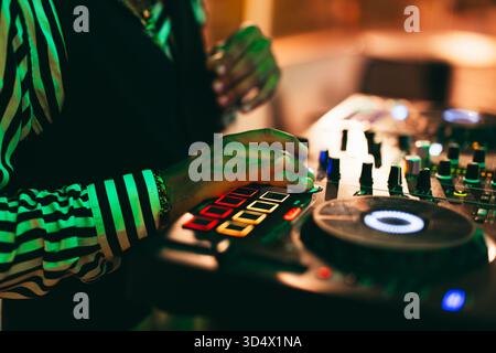 DJ spielt Musik während der Winterfeier in der Cocktailbar - Entertainment und Clubbing Konzept - Soft Focus auf Disc Jockey in der rechten Hand Stockfoto