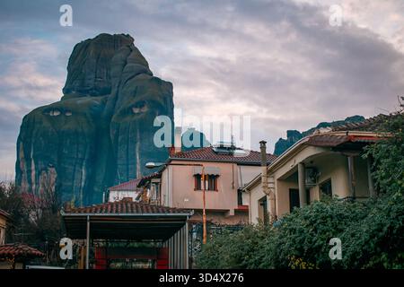 Ein Dorf am Fuße von Bergformationen bei Sonnenaufgang. Meteora, Griechenland. Stockfoto
