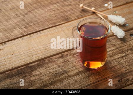 Türkischer schwarzer Tee. Eine Glasschale türkischer schwarzer Tee und knuspriger türkischer traditioneller Bagel auf altem Rustick-Hintergrund. Frühstücksgebäck-Konzept. Traditionelles türkisches Heißgetränk. Stockfoto