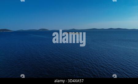 Hochwinkelansicht mit einer ruhigen Meereslandschaft, wahrscheinlich im Mittelmeer oder an der Adria, gekennzeichnet durch intensives blaues Wasser, das sich in der Farbe vertieft Stockfoto