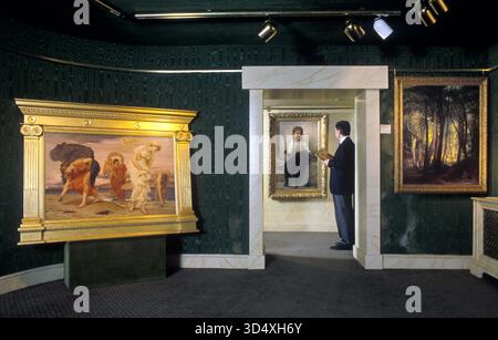 Kunsthändler 1990s in der Galerie The Belgravia Art Gallery London 1999 UK . (L) Griechische Mädchen, die Kieselsteine von Lord Frederic Leighton HOMER SYKES aufsammeln Stockfoto