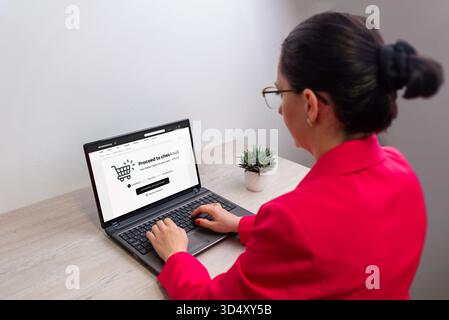 Frau, die einen Laptop für den Online-Checkout verwendet, den Bildschirm für E-Commerce-Zahlungen, das Konzept des digitalen Einkaufs, die Internettransaktion und die sichere pu Stockfoto