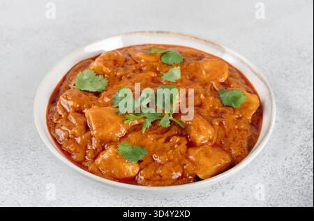 Indisches Butterhähnchen in cremiger Tomaten- und Gewürzsauce mit Koriander. Konzeptmenüs, Blogs, Lieferung, Kochbücher. Stockfoto