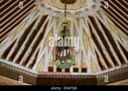 Marokkanische Lampe im Bahia Palace, Marokko. Innenraum des Bahia Palace mit Lampe, die von der Decke hängt. Stockfoto