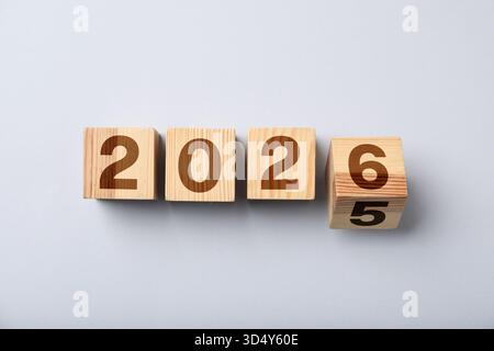 Neujahr. Würfel mit den Zahlen 5 und 6 wird umgedreht, um 2026 auf grauem Hintergrund zu machen, Draufsicht Stockfoto