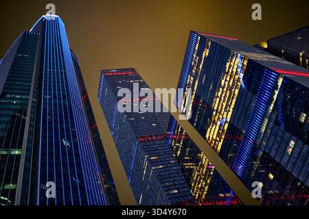 Blick von unten auf moderne Wolkenkratzer, beleuchtet bei Nacht. Moscow International Business Centre (MIBC) aka Moscow City, Moskau, Russland. Stockfoto