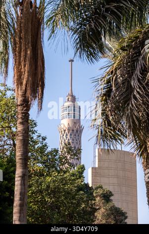 Blick aus der Vogelperspektive auf den berühmten Cairo Tower, der die Skyline inmitten üppiger Vegetation durchquert und von sich wiegenden Palmen eingerahmt wird, Kairo, Ägypten. Stockfoto