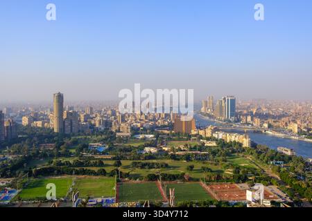 Blick aus der Vogelperspektive auf die weitläufige Stadtlandschaft am Nil, mit üppigen grünen Parks, die sich von der Skyline der Stadt in Kairo, Ägypten, abheben. Stockfoto
