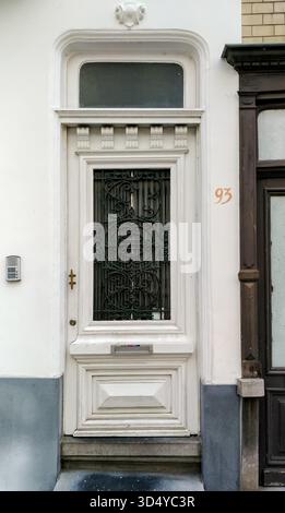 Ostende, Belgien - 30. Juni 2019 - kunstvoll verzierte weiße Tür mit aufwändigen Schmiedearbeiten und Heckfenster. Stockfoto