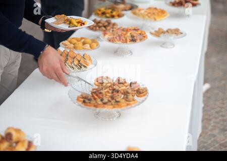 Elegante private Veranstaltung mit einem üppigen Buffet mit vielfältigen kulinarischen Köstlichkeiten und Gästen, die die Festlichkeiten genießen Stockfoto