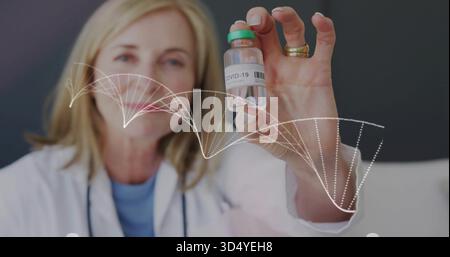 Leitende Ärztin mit COVID-19-Durchstechflasche in der Klinik, mit weißem Labormantel und DNA-Helix-Überlagerung Stockfoto