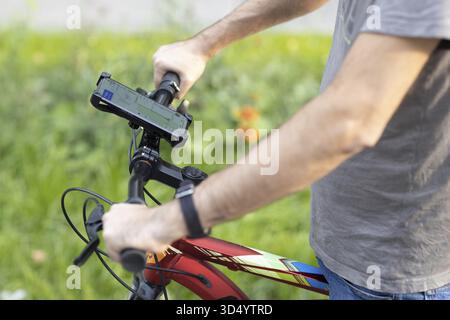 Mann plant Route mit GPS-Navigations-Anwendung im Handy auf seinem Fahrrad Stockfoto