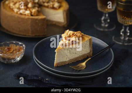 Essen, Stück Käsekuchen mit Popcorn und gesalzener Karamellsauce auf dunkelblauem Hintergrund, selektiver Fokus Stockfoto