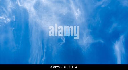 Eine wunderschöne und ruhige Weite voller weicher, strahlend weißer Wolken, die sanft über einen leuchtend blauen Himmel gleiten, macht es zur perfekten Wahl für Hintergründe und Naturthemen aller Art Stockfoto