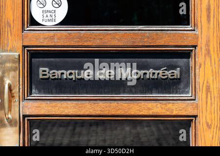 Montreal, Kanada - 11. August 2025: Hölzerne Eingangstür mit Banque de Montreal-Schild im historischen Gebäude am Place d'Armes in Old Montreal Stockfoto