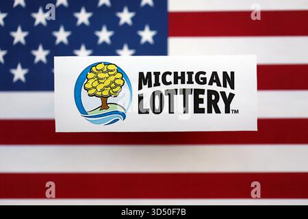 KIEW, UKRAINE - 22. OKTOBER 2025 Michigan Lotterie Lotterie Service Firmenlogo auf US-Flagge Nahaufnahme Stockfoto